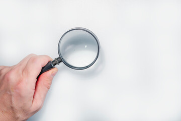 Hand holding magnifier tool isolated on white background. discover and research concept.