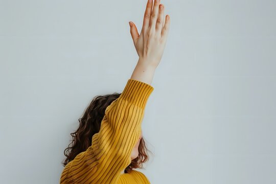 Woman Raises Hand High in the Air, Showing a Gesture of Hope and Freedom, a Symbol of Empowerment and Optimism for a Better Tomorrow; Exploring Nonverbal Communication and Body Language.