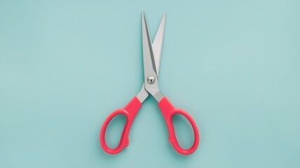 scissors with bright red handles and sharp silver blades, slightly open and isolated on a pastel blue background