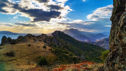 Mountain landscape with dramatic clouds, serene mood, sunset over hills, natural view