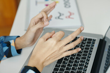 High angle closeup of unrecognizable female hands gesticulating during video call via laptop in...