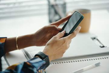 Closeup of unrecognizable female office worker hands scrolling web page on smartphone