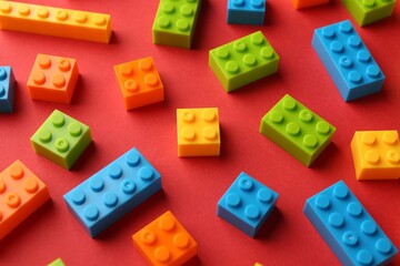 Construction toy. Colorful building bricks on red background, closeup
