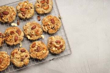 Tasty cookies with nuts on gray textured table, top view. Space for text