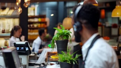 A cheerful barista interacts with patrons crafting delicious drinks in a lively cafe filled with energy and conversation