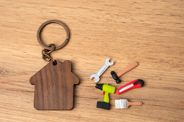 Figurine of a house and repair tools: spanner, brushes, hammer, stationery knife, plasterer....