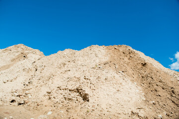 mountain of sand against blue sky