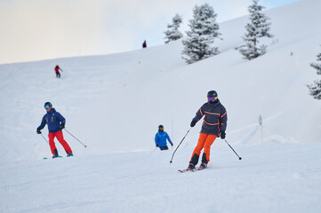 Generated imageGroup of skiers enjoying a descent on pristine snowy slopes in the Alps, surrounded by winter scenery and fresh mountain air. Extreme sport and holiday concept.