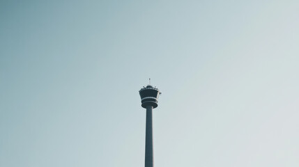 Low angle shot of towering observation tower against clear sky, showcasing its impressive height and architectural design, evoking sense of wonder and exploration