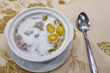 A serving of Orh Nee in bowl with spoon. It is popular traditional teochew sweet dessert consisting yam, gingko and lard in Malaysia.