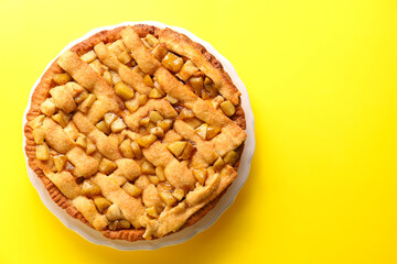 Tasty homemade apple pie on yellow background, top view. Space for text