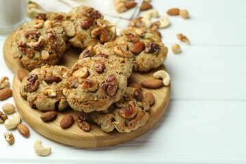 Tasty cookies with nuts on white wooden table, closeup. Space for text