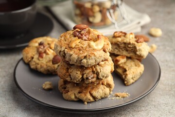 Tasty cookies with nuts on gray textured table, closeup