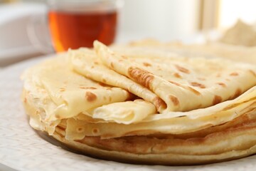 Tasty thin crepes on plate, closeup view