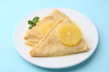 Delicious Crepes Suzette on light blue background, closeup
