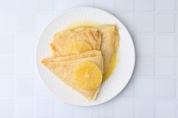 Delicious Crepes Suzette on white tiled table, top view