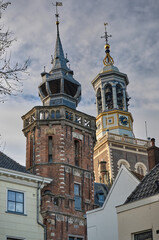 City Hall Brick Tower in Kampen, The Netherlands, with the Nieuwe Toren behind it, against cloudy sky