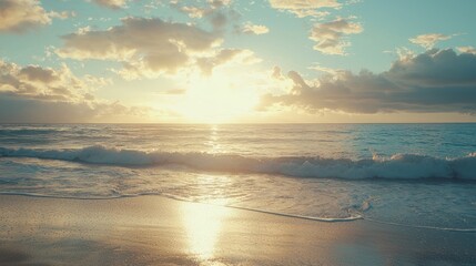 Fototapeta premium Golden sunset over ocean waves on sandy beach.