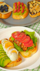 Healthy toasts for breakfast with blueberry, honey, cheese, avocado, egg, tomato, chicken, lettuce, strawberry, almond and chocolate.
