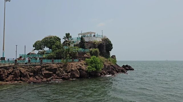 Dona Paula Beach Pavilion A small rocky island with greenery and a structure on top, the Dona Paula viewpoint