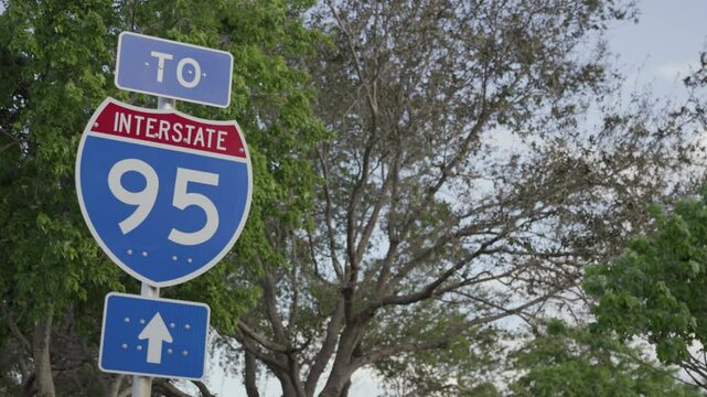 Static handheld shot of Interstate 95 highway sign with trees in background, captured in south Florida.