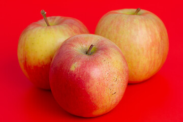 Three apples on a red background. Fruit, apple.