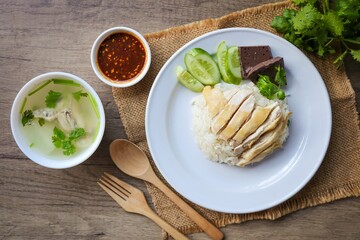 Chicken and rice with coriander and cucumber with sauce and soup in a white plate, hainanese chicken rice, thai called khao man gai, asian food, thai food
