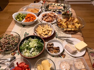 Christmas table family celebration feast cold buffet delicious fish dishes courgette lemon decorates salmon prawn rings tails langoustin spring rolls salads and vegetables with pickles cheese biscuits