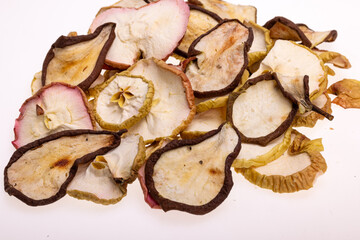 Closeup of a pile of dried slices of pears and apples isolated on a white background. Healthy raw vegetarian eat from thin fruit chips of sweet and sour flavor