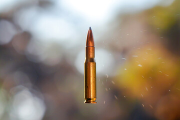 A high-speed bullet in flight, showcased with a clear sky in the background, emphasizing motion and accuracy.