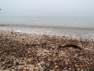 The sea and a shingle beach with the tide coming in waves