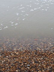 The sea and a shingle beach with the tide coming in waves