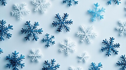 A collection of intricate blue and white snowflakes scattered on a light background, evoking a wintry, festive atmosphere.