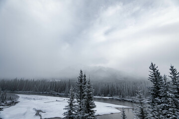 Obraz premium Winter landscape in Alberta, Canada with a river and conifer trees