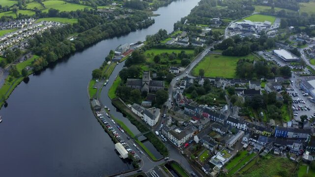 St Flannan's Cathedral, Killaloe, County Clare, Ireland, September 2021. Drone pushes towards the medieval church into a high angle with Shannon riverfront beside the architecture and graveyard.