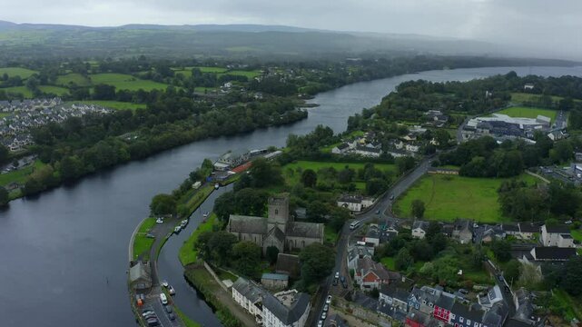St Flannan's Cathedral, Killaloe, County Clare, Ireland, September 2021. Drone orbits counter clockwise around the medieval architecture as a misty fog sets in on the banks of the Shannon River.