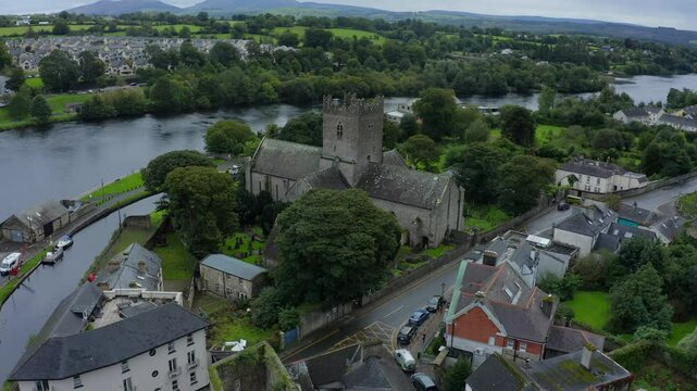 St Flannan's Cathedral, Killaloe, County Clare, Ireland, September 2021. Drone orbits counter clockwise and ascends high above the medieval architecture with the River Shannon in the background.