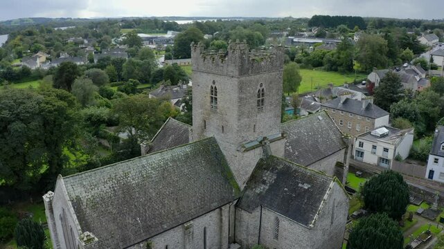 St Flannan's Cathedral, Killaloe, County Clare, Ireland, September 2021. Drone orbits counter clockwise while pulling backward over the graveyard with the River Shannon winding through the background.