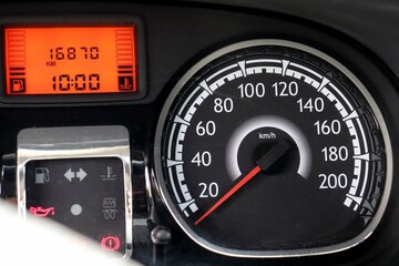 Close-up of a car panel with a speedometer indicating. 