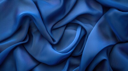 Obraz premium A close-up view of a blue satin fabric, showcasing its smooth and flowing texture with natural folds and shadows.