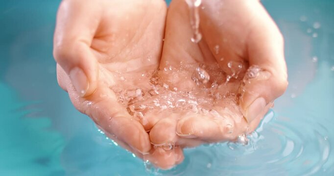 Clean drinking water flows in the palms of the woman hands. Shot on super slow motion camera 1000 fps.