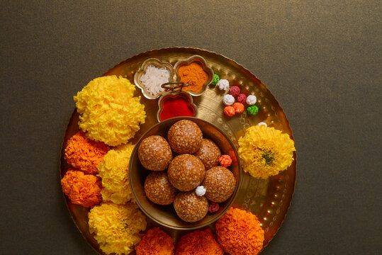 A puja thali for Makar Sankranti festival consists of Tilgul, flowers and haldi kumkum. Hindu religious objects and food.