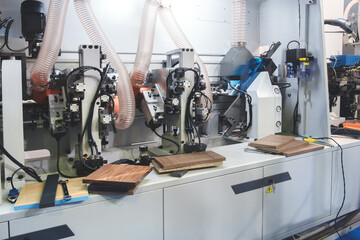 Wood boards on a woodworking machine in a modern furniture factory, woodworking industrial concept background