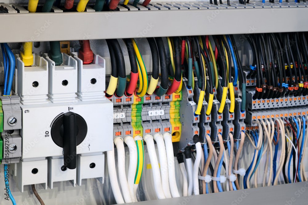 Poster picture of a bunch of wires and cables with a switch on the left. the switch is black and has a whit