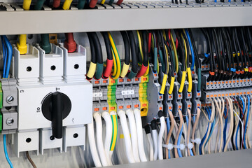 Picture of a bunch of wires and cables with a switch on the left. The switch is black and has a white knob. The wires are of different colors and lengths