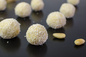 Homemade raw vegan coconut truffles - coconut balls aka Raffaello on the black table