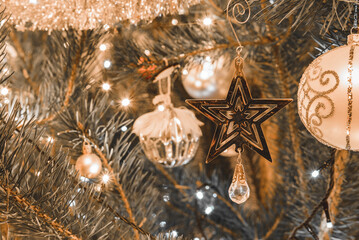 Srebrna gwiazda zawieszona na zielonej gałązce choinki, delikatnie połyskująca w świetle lampek. Subtelne refleksy i rozmyte tło tworzą magiczną, świąteczną atmosferę. © Radek