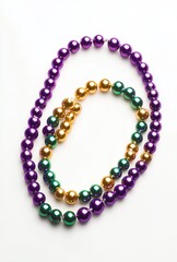 Fototapeta premium Colorful Decorative Beads in Purple, Green, and Gold Arranged on a White Background for Festive Occasions and Celebrations