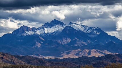 Majestic Snow-Capped Mountains Under Dramatic Cloudy Sky