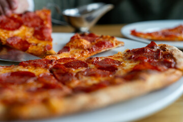 low view of Freshly Baked Pepperoni Pizza Served on White Plates